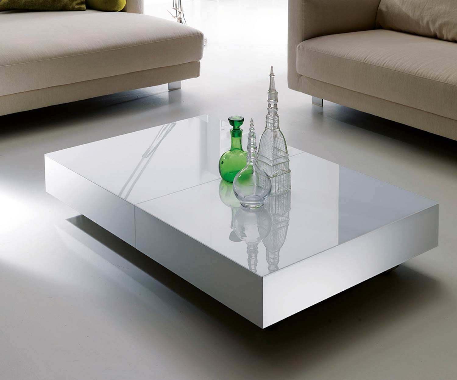 Witte glazen design salontafel van Ozzio met bank en fauteuil in de woonkamer