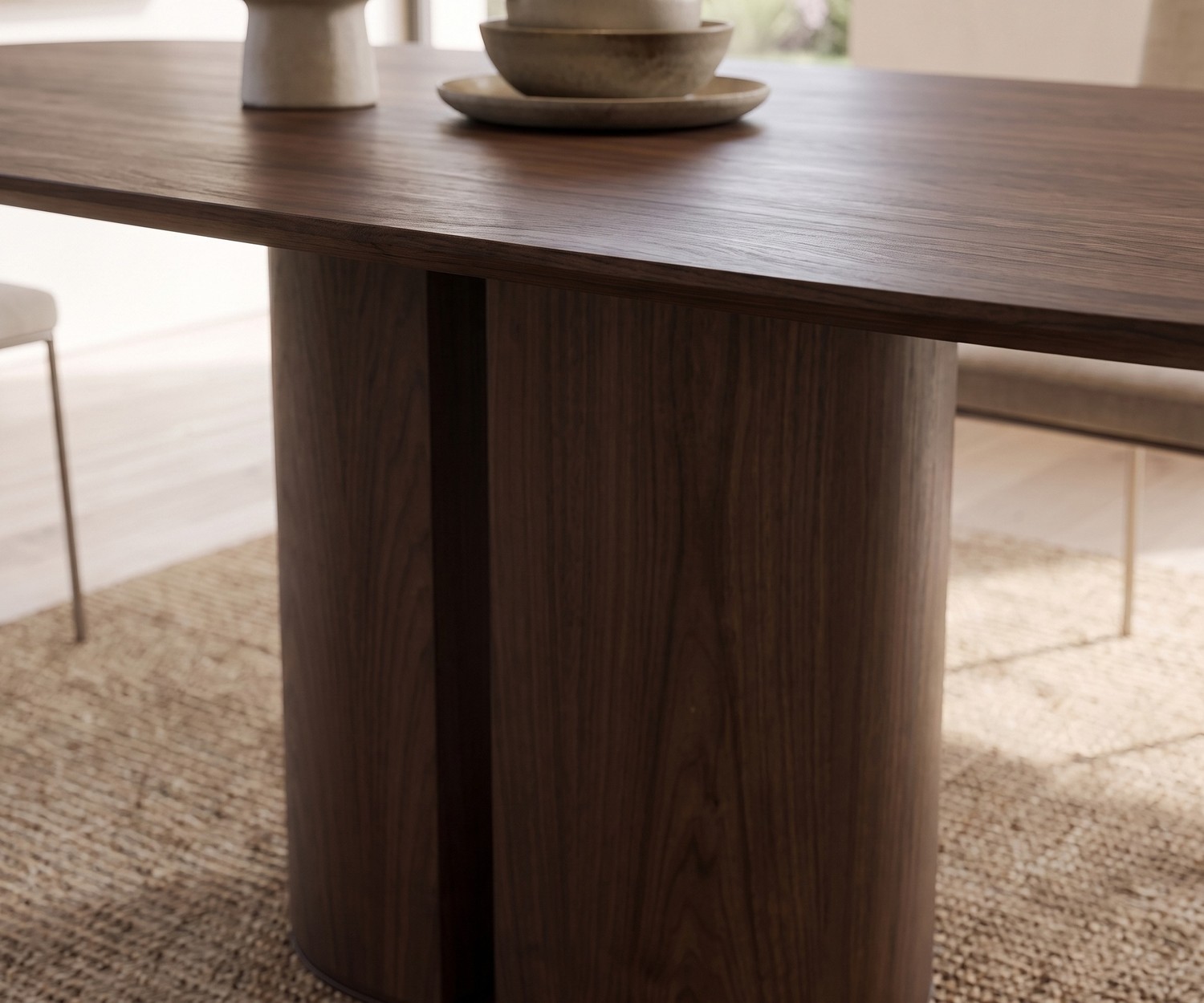 Design eettafel al2 el-it c 001 in donker houtfineer met cilindrische poot in de eetkamer op een vloerkleed.