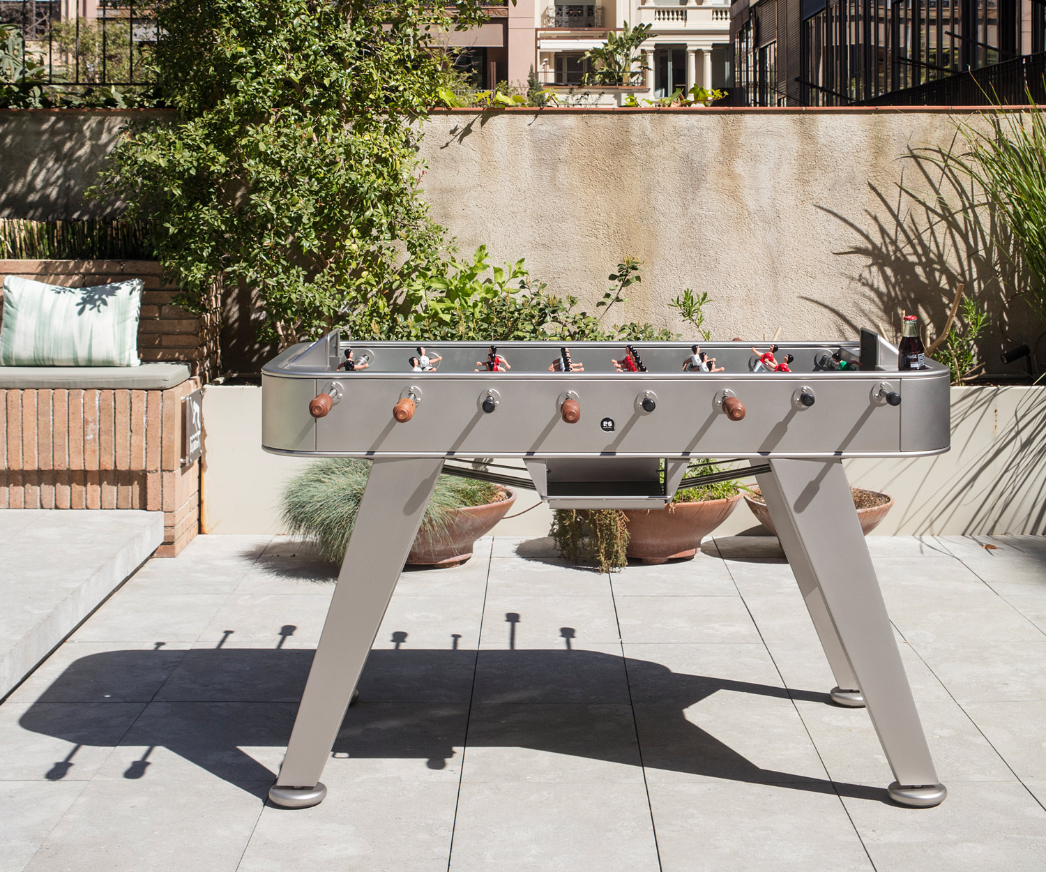 Zilverkleurige RS Barcelona tafelvoetbaltafel op het terras Zilverkleurige RS Barcelona tafelvoetbaltafel op het terras