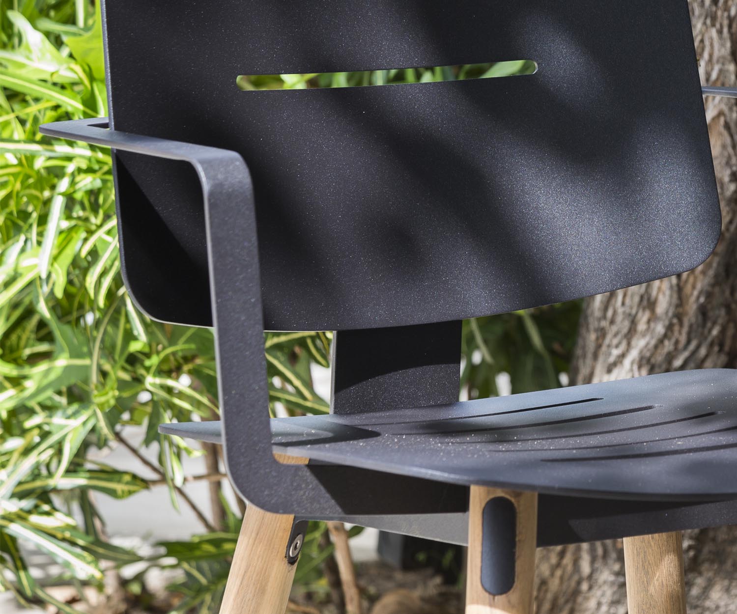Moderne Oasiq Coco stalen stoel met armleuningen teak met aluminium achterpoten 