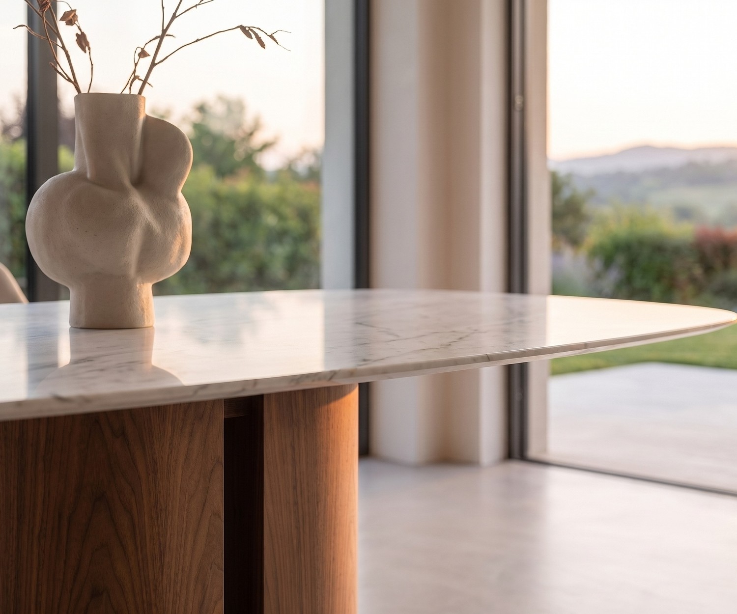 al2 el-it c 001 eettafel met marmerlook blad al2 el-it c 001 eettafel in een moderne eetkamer met wit marmerlook blad, houten zuilvoet en decoratieve vaas.