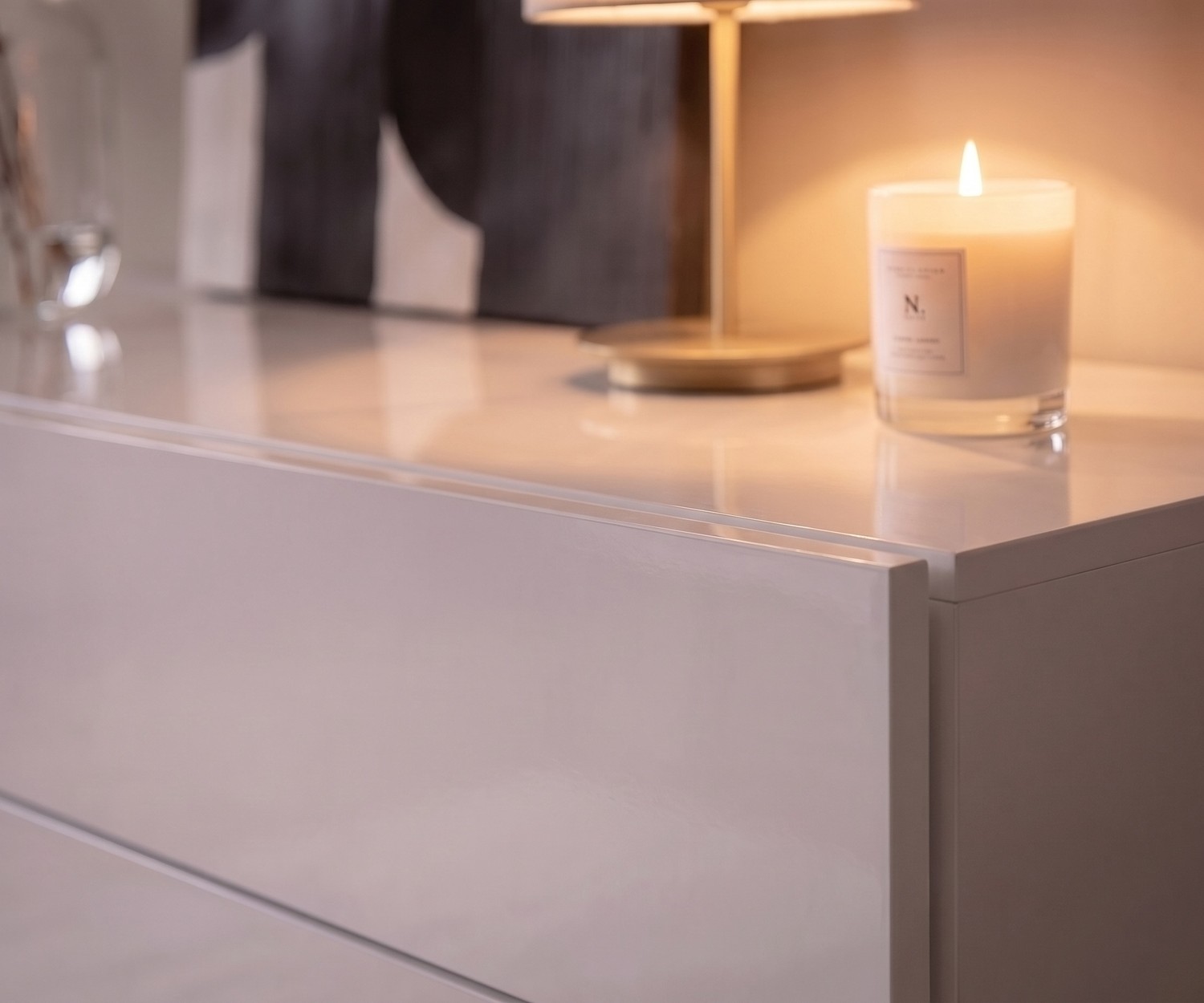 Novamobili Easy zwevende commode in wit hoogglans Zwevende commode Novamobili Easy voor de slaapkamer. Moderne witte hoogglans ladekast zonder grepen met sfeervolle kaars.