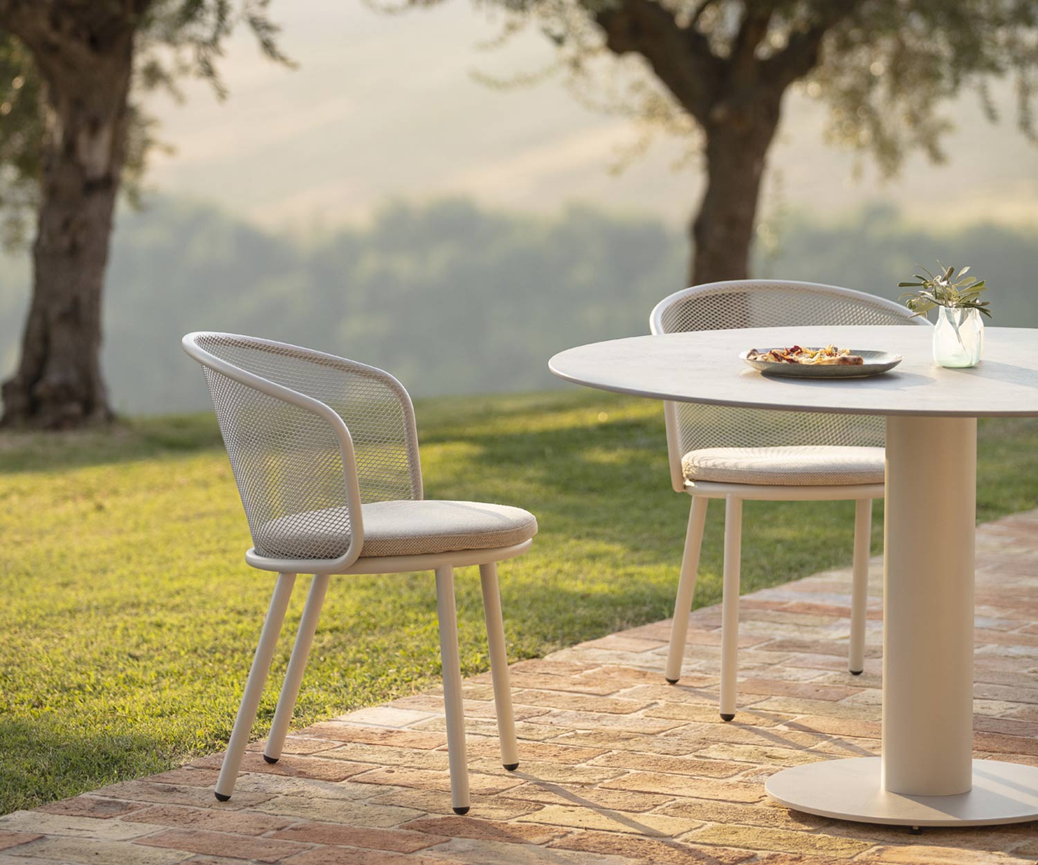 Witte Todus Baza design fauteuil met grijze stoffen bekleding in de tuin Witte Todus Baza design fauteuil met grijze stoffen bekleding in de tuin