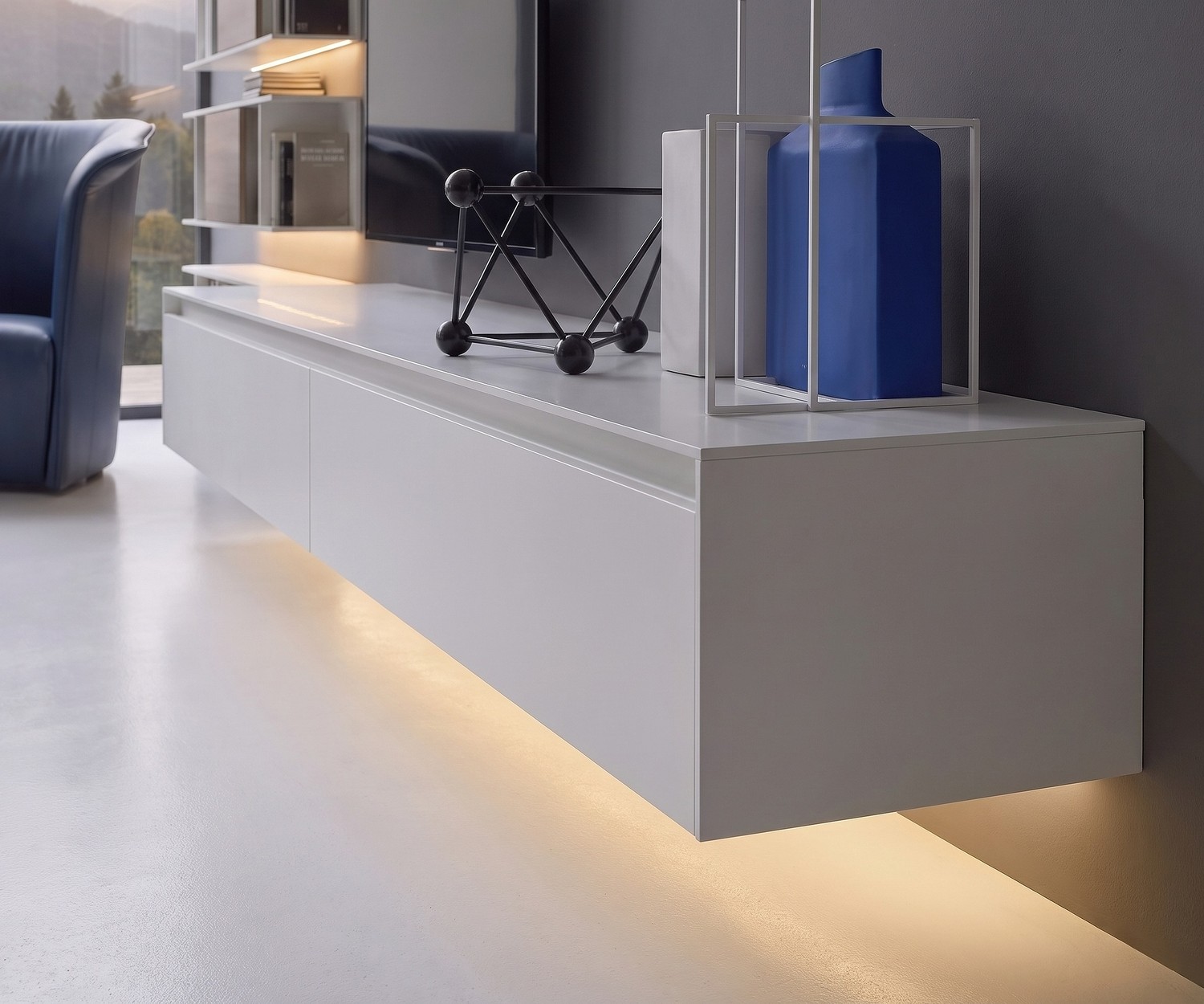 Zwevend TV-meubel Novamobili Reverse in wit met sfeervolle LED-onderverlichting in de woonkamer