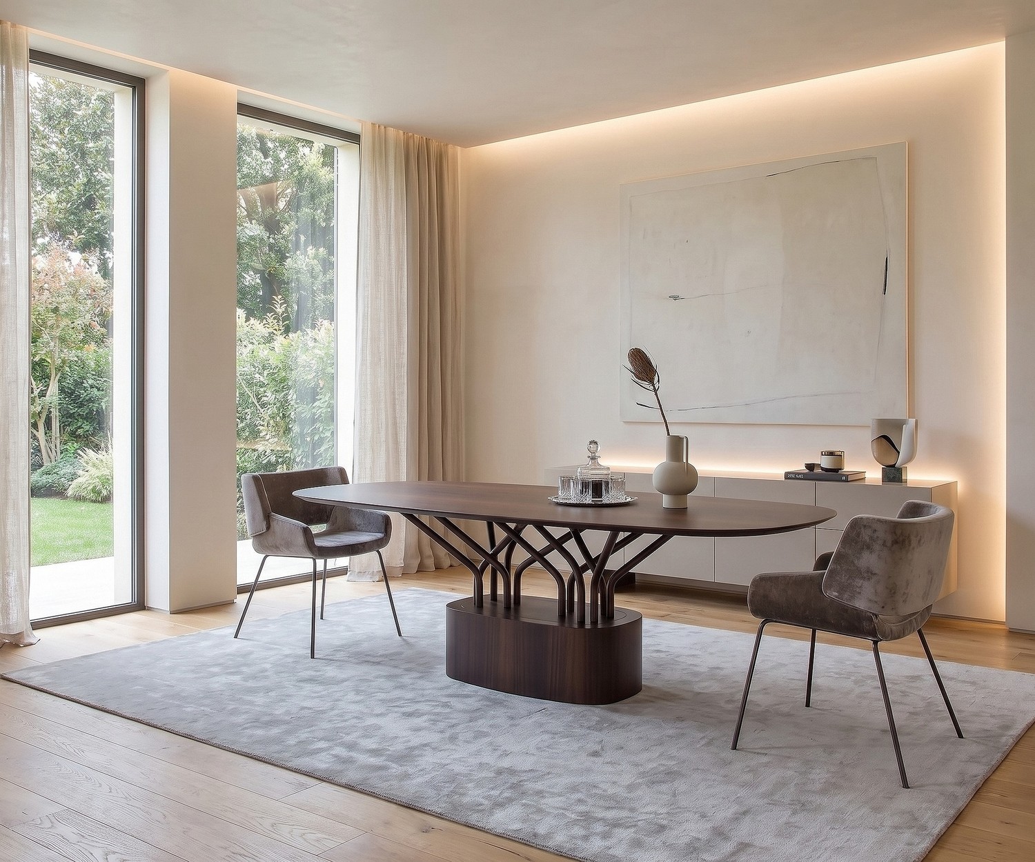 al2 wood-oo ovale design eettafel Ovale al2 wood-oo houten eettafel in een moderne eetkamer met twee grijze fluwelen stoelen en grote ramen.
