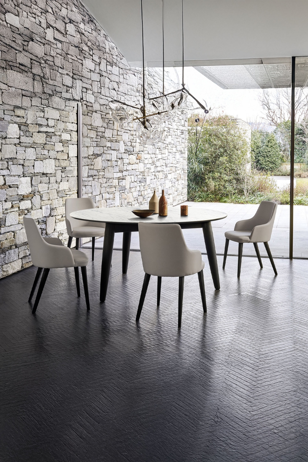 ronde-eettafel-en-gebogen-stoelen-in-zwart-wit-naast-een-muur-in-steenlook