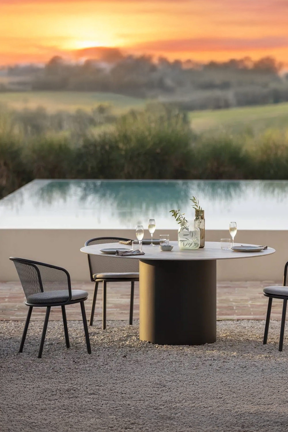 ronde-tuintafel-met-moderne-stoelen-voor-groot-zwembad