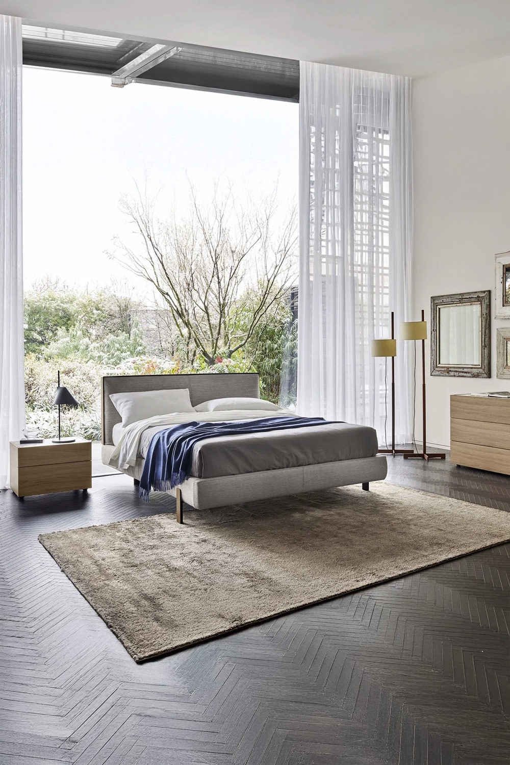 slank-omlijst-bed-met-zwevend-effect-en-greeploos-nachtkastje-voor-een-groot-raam