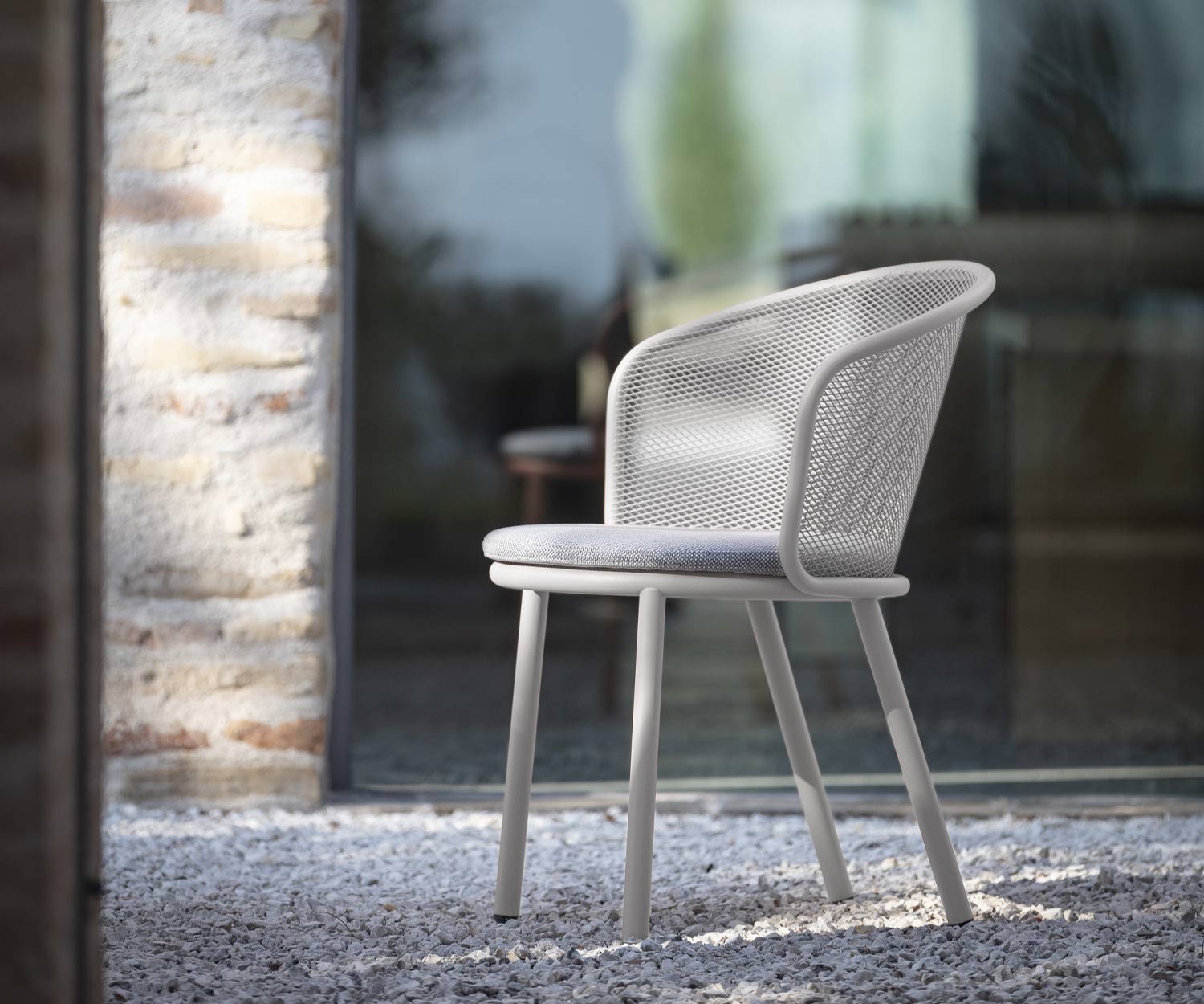 Witte Todus vrijetijdsstoel met grijze bekleding op grindoppervlak