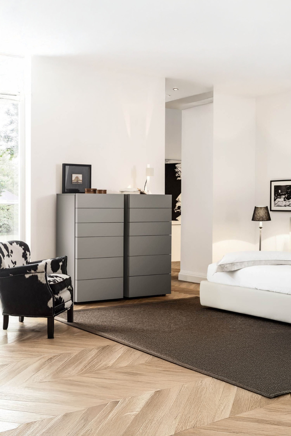 moderne-ladekast-met-greeploze-fronten-tussen-een-elegant-bed-en-extravagante-fauteuil