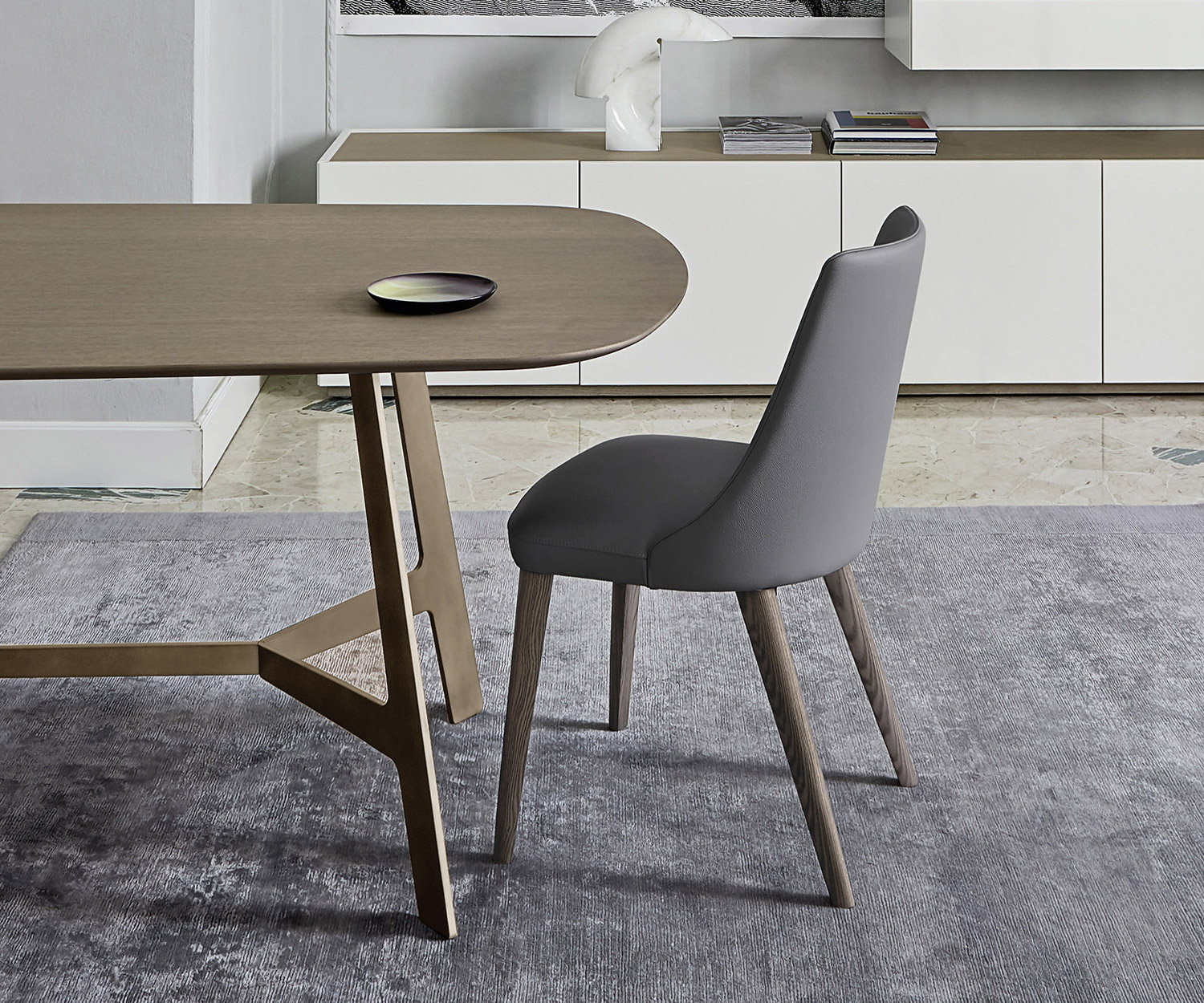 Hoogwaardige designstoel Eva van Livitalia met grijze kunstlederen bekleding aan de eettafel Hoogwaardige designstoel Eva van Livitalia met grijze kunstlederen bekleding aan de eettafel
