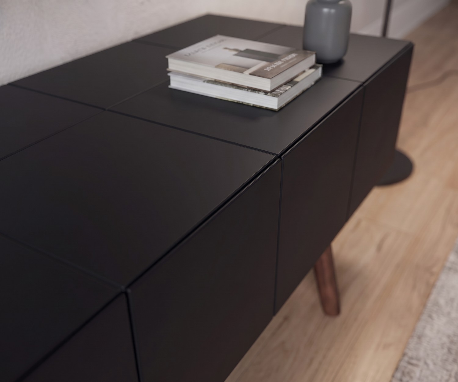 al2 design lowboard MOS-I-KO 005 B in mat zwart al2 TV-lowboard MOS-I-KO 005 B in mat zwart voor de woonkamer, close-up van greeploos front en houten poten in retrostijl.