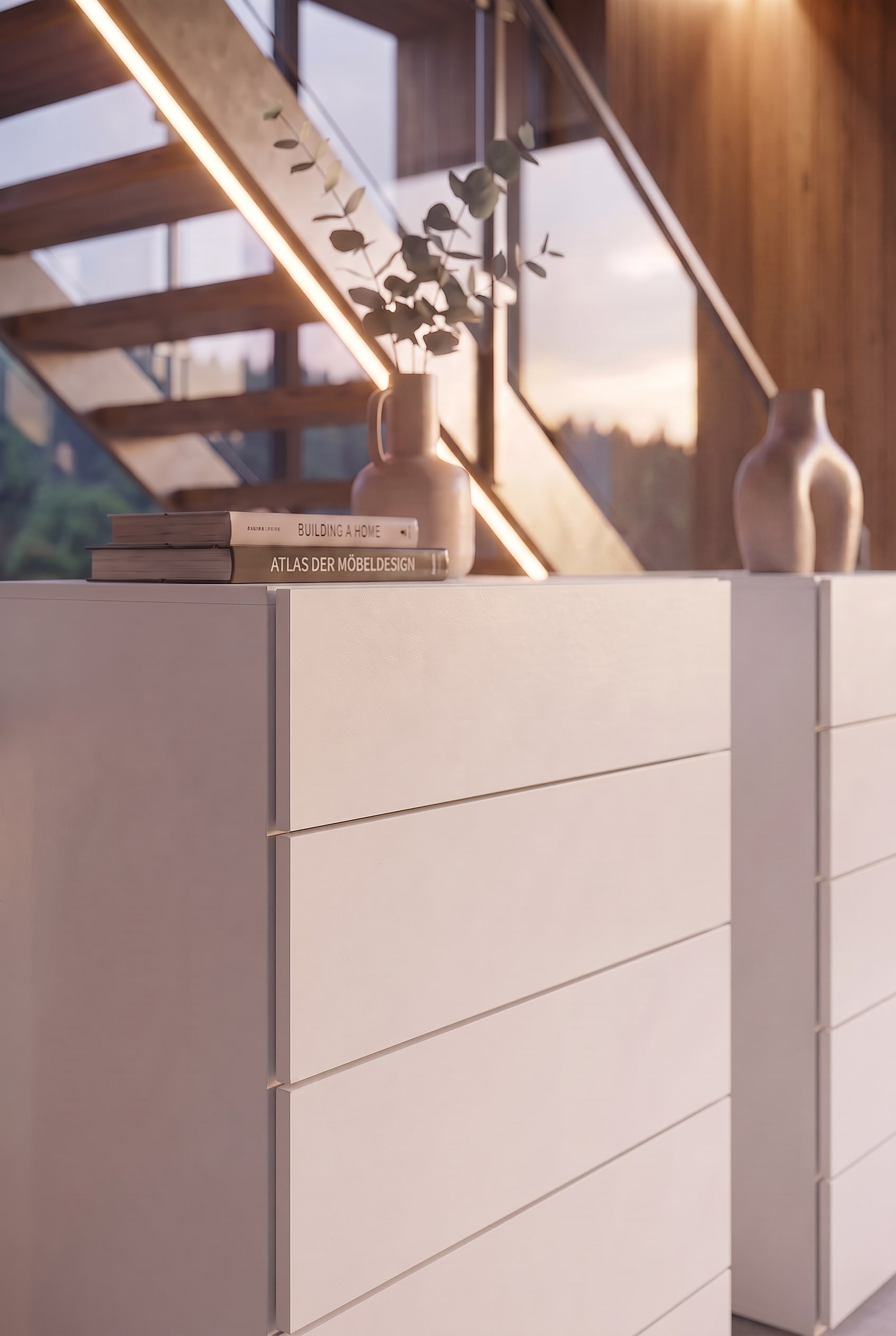 Detail einer wei&szlig;en Kommode mit Design-B&uuml;chern und einer Keramikvase im warmen Sonnenlicht.