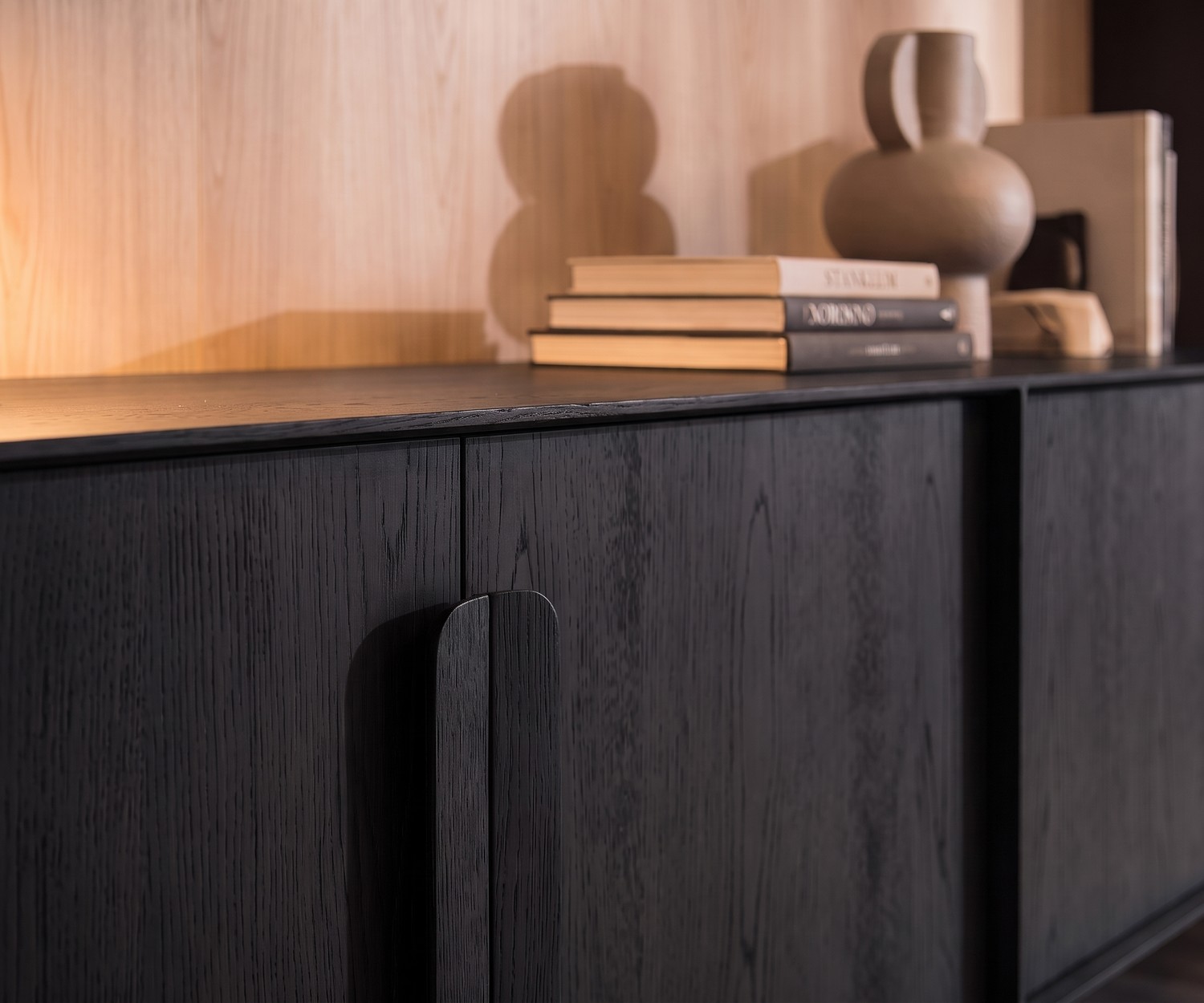 Modern al2 Mobius 003 dressoir in zwart eiken Mobius 003 dressoir van al2 in zwart eikenfineer met houten handgrepen in een moderne woonkamer.