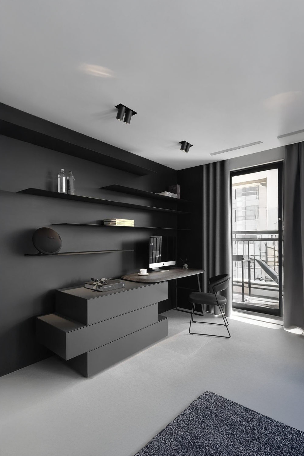 donkergrijs-ingerichte-werkkamer-met-verspringende-laden-en-planken