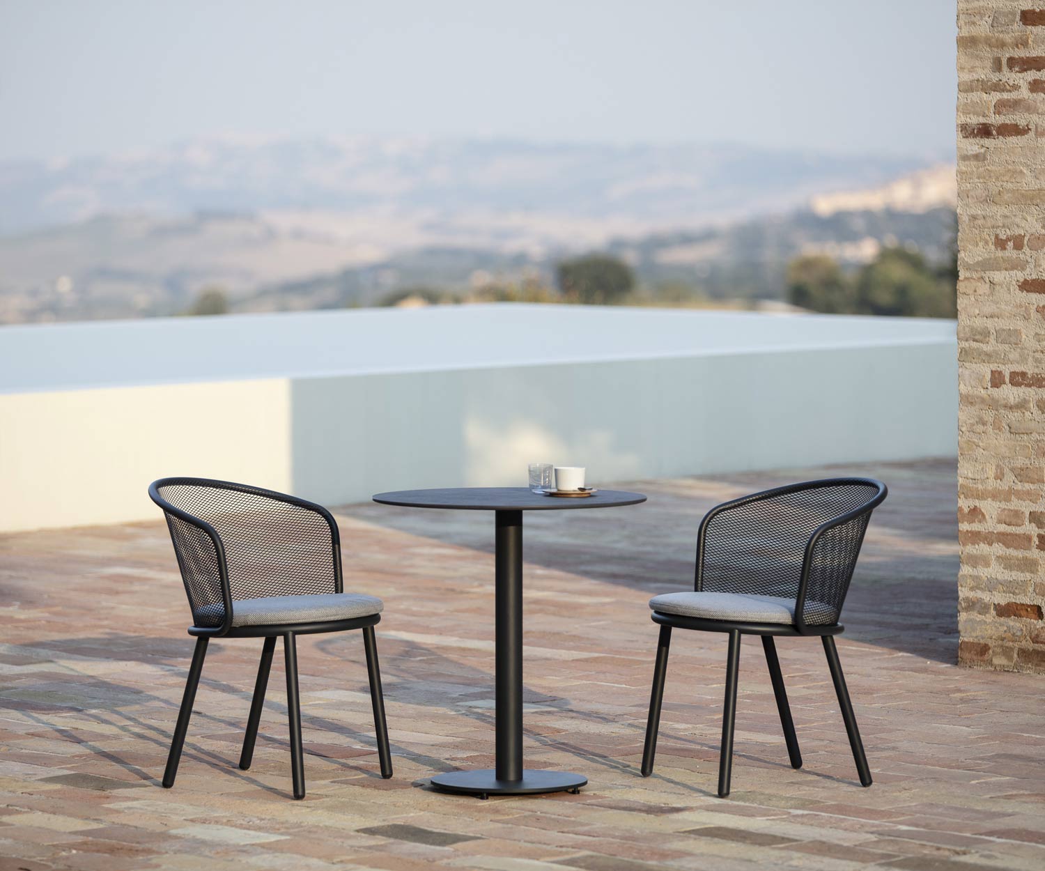 Hoogwaardige Todus Baza design tuinstoel met bijzettafel op terras Hoogwaardige Todus Baza design tuinstoel met bijzettafel op terras
