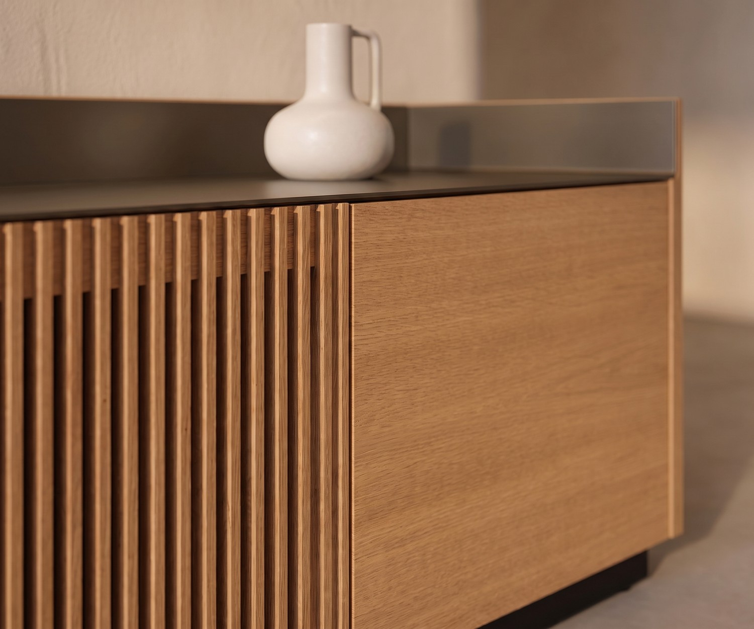 Punt Stockholm TV-lowboard van eikenhout met lattenfront en aluminium bovenblad in een modern interieur.