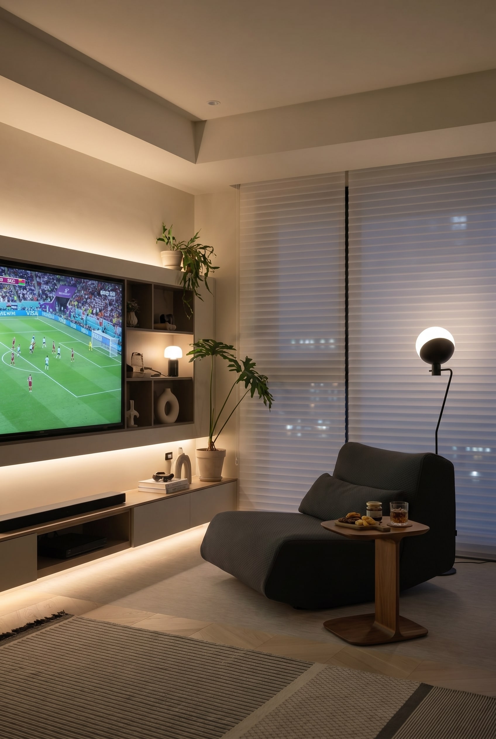 Ergonomischer, dunkelgrauer Lounge-Sessel in einer hellen Ecke mit bodentiefen Fenstern und einer Stehlampe