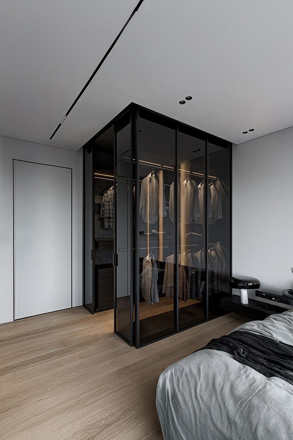 donkere-kledingkast-met-transparante-deuren-naast-een-bed