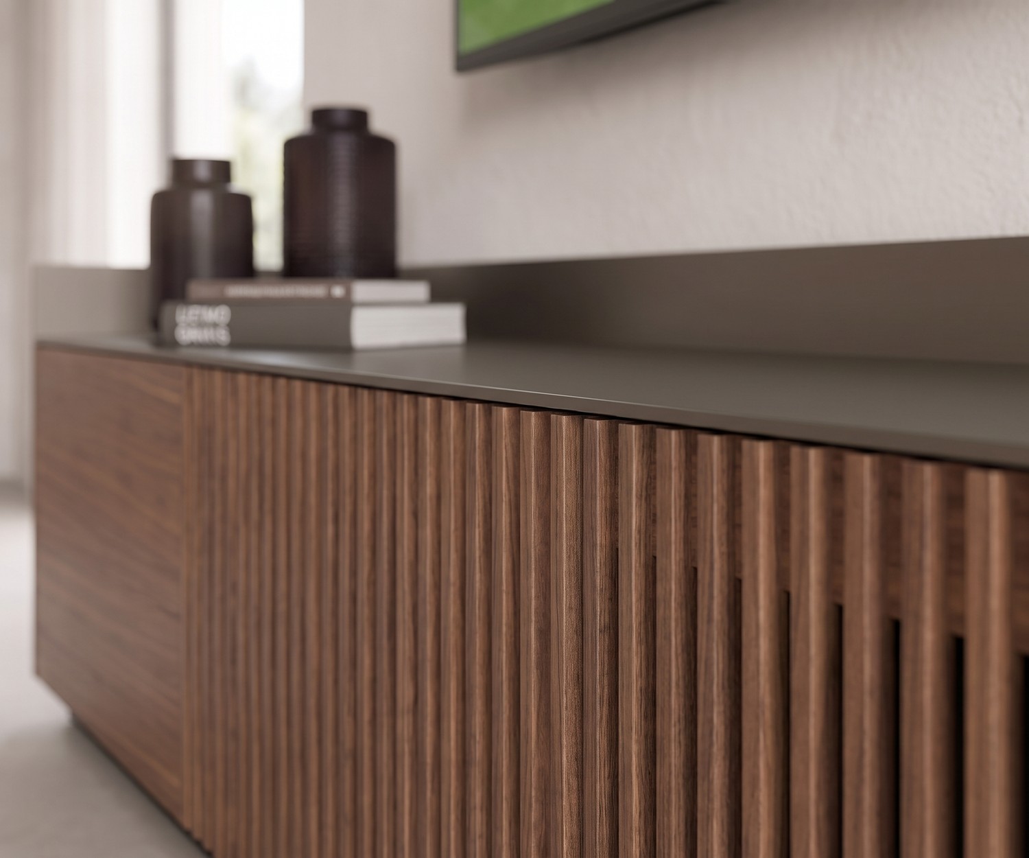 Punt Stockholm TV-lowboard met lattenstructuur Punt Stockholm tv-meubel met houten lattenfront in walnoot en aluminium blad in een moderne woonkamer.